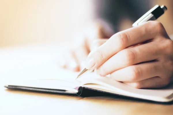 Female hands writing in notebook — Stock Photo, Image