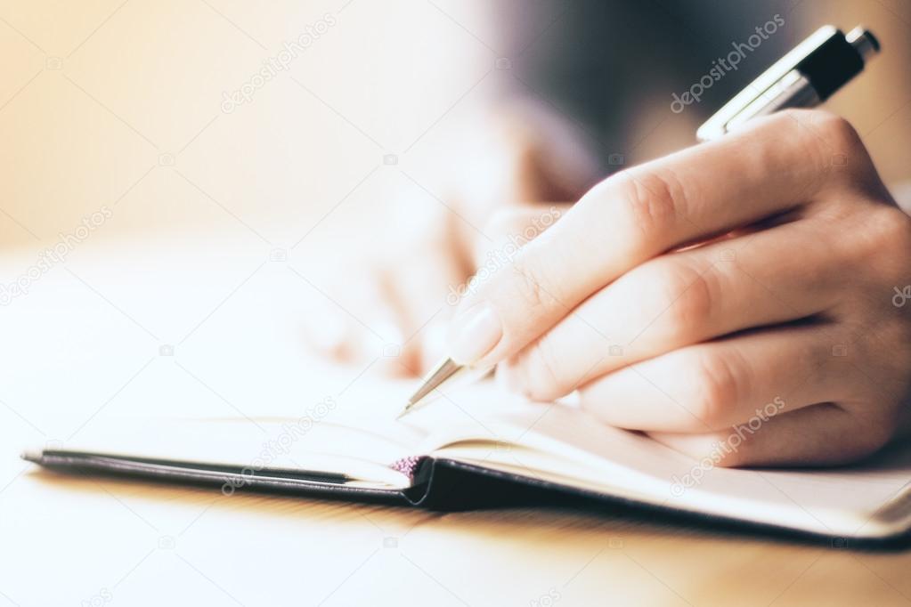 Female hands writing in notebook