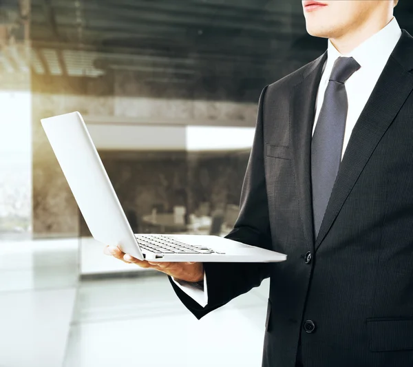 Affärsman med öppnad laptop i ena handen — Stockfoto
