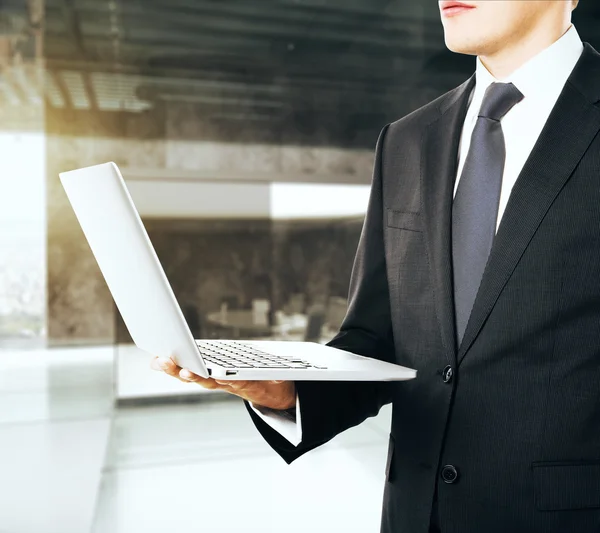 Geschäftsmann mit geöffnetem Laptop in der einen Hand — Stockfoto