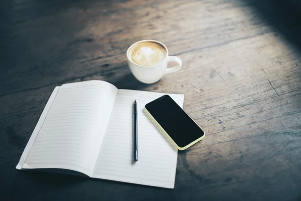 Abra notebook em branco, caneta, telefone celular e xícara de café em madeira — Fotografia de Stock