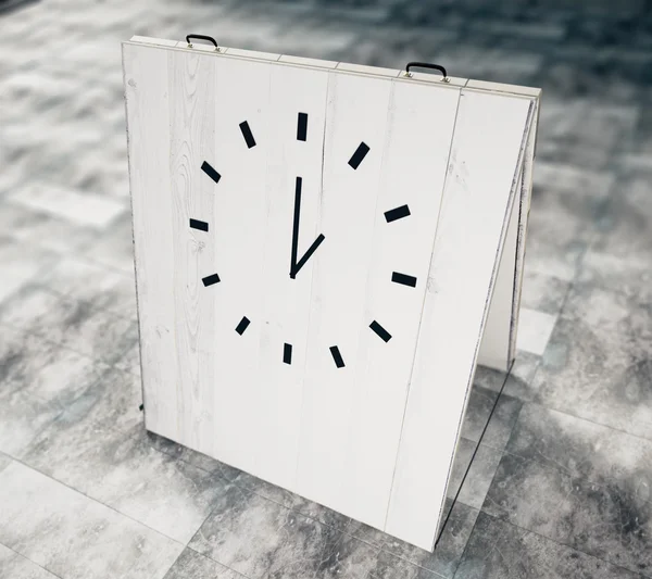 Годинник на білій дерев'яній дошці на бетонній підлозі — стокове фото
