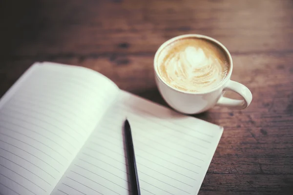 Tagebuch mit Stift und Kaffeetasse auf einem Holztisch — Stockfoto