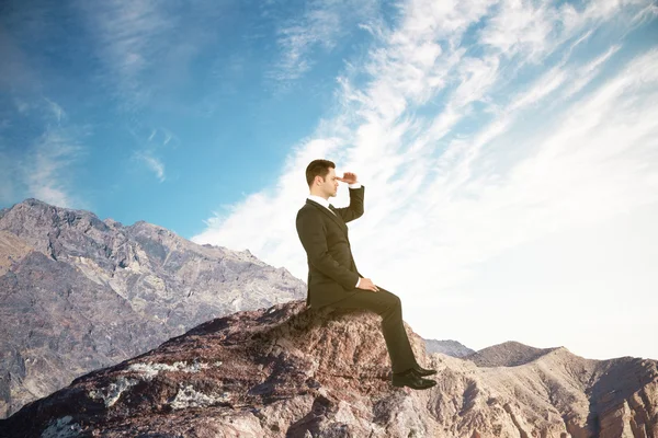 Бізнесмен сидить на вершині гори — стокове фото