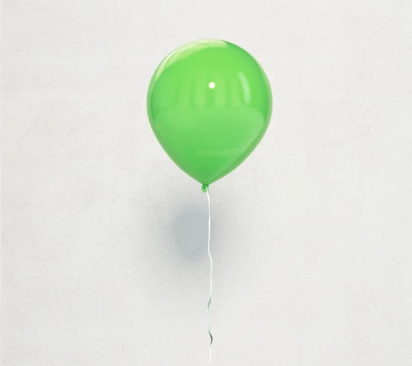 Balão verde na parede de concreto leve fundo — Fotografia de Stock