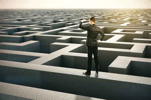 Solution concept with businessman looking into the distance standing on maze wall. — Stock Photo, Image