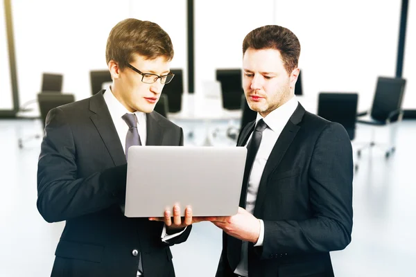 Dois empresários discutindo algo no laptop na sala de conferências interior — Fotografia de Stock