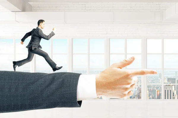 Businessman running on arm pointing forward — Stock Photo, Image