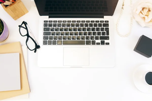 Vedere de sus a desktop-ului de designer feminin cu flori, laptop, ochelari, ceașcă de cafea și alte articole — Fotografie, imagine de stoc