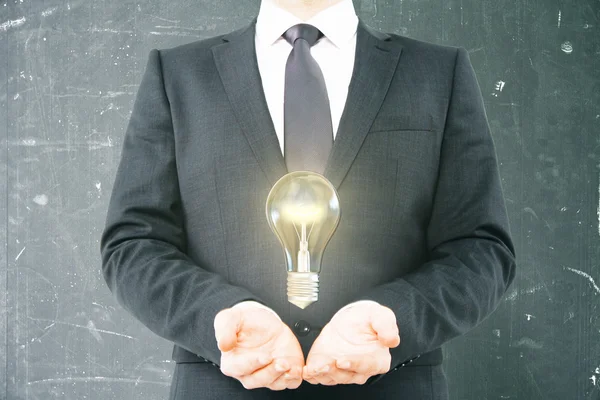 Idea concept businessman holding bulb — Stock Photo, Image