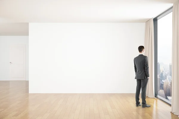Uomo d'affari in camera con parete bianca — Foto Stock