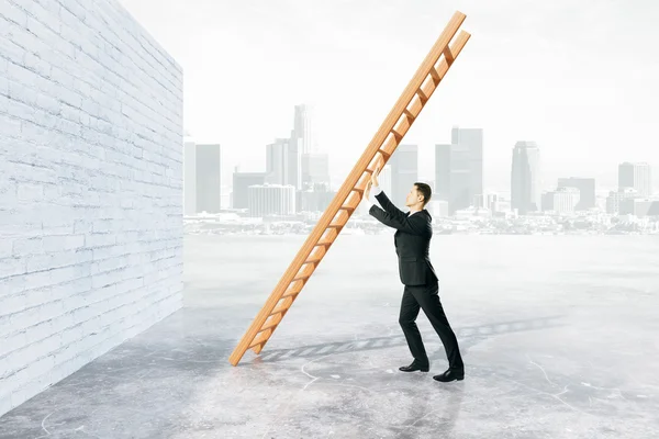 Hindernis overwinnen van concept met zakenman duwen ladder om bakstenen muur op mistige stad achtergrond. — Stockfoto