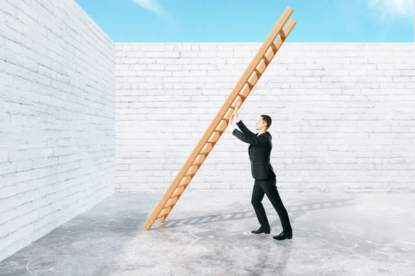 Человек толкает лестницу к стене — стоковое фото