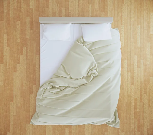 Unmade bed on wooden floor — Stock Photo, Image