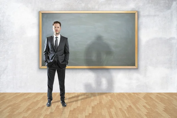 Geschäftsmann steht im Raum und wirft einen Schatten in Form eines Dollarzeichens. Bildungskonzept. 3D-Darstellung — Stockfoto