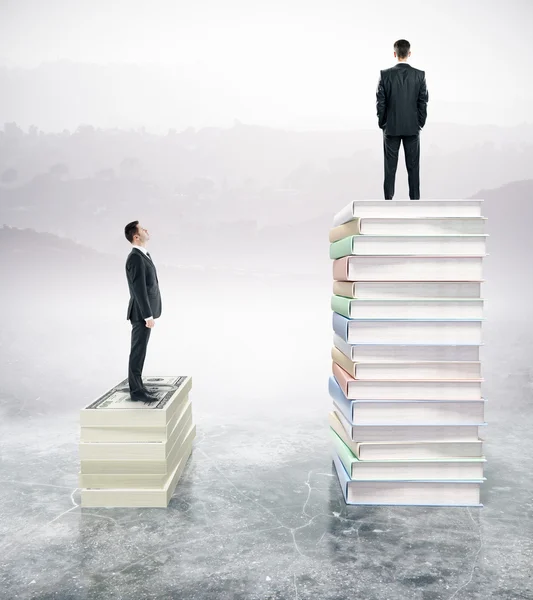 Двоє бізнесменів стоять на стосі книг — стокове фото