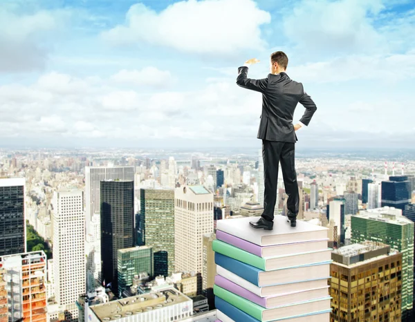 Businessman standing on stack of books — Stock Photo, Image