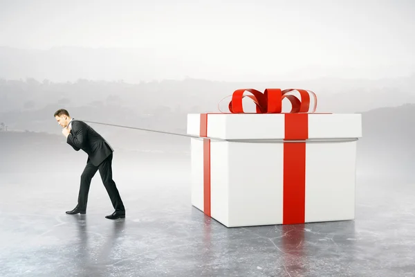 stock image Businessman dragging present