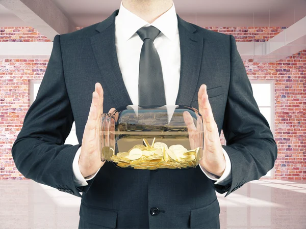 Man with coins in brick room — Stock Photo, Image