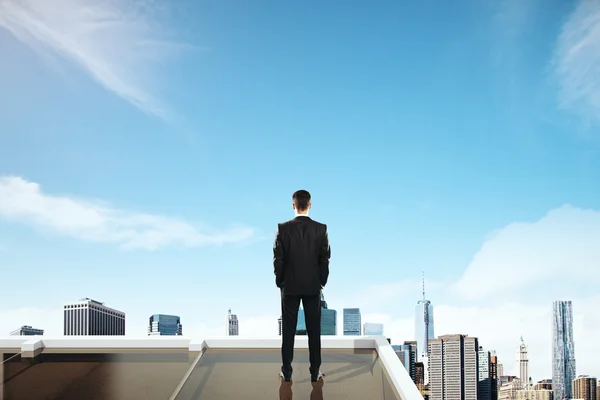 Concepto de investigación con hombre de negocios en la azotea mirando al cielo y la ciudad. Lado trasero — Foto de Stock