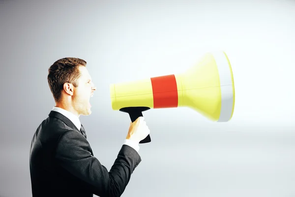 Businessman screaming into megaphone — Stock Photo, Image