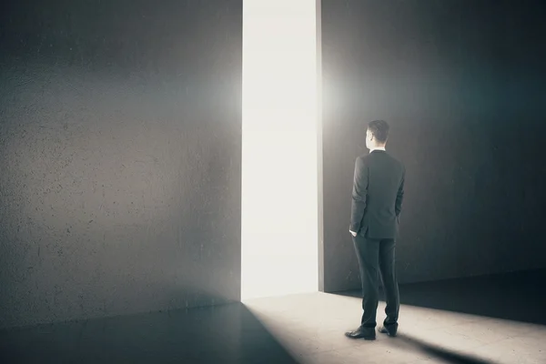 Homme d'affaires regardant par l'ouverture abstraite dans le mur avec la lumière du jour dans l'intérieur en béton. Concept de recherche. Rendu 3D — Photo