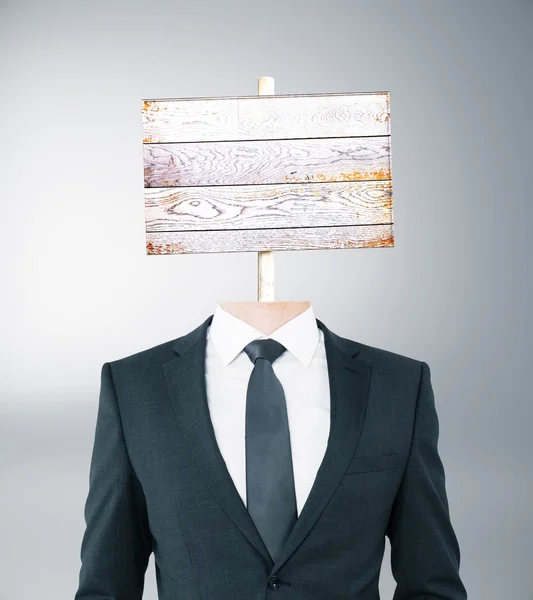 Wooden signboard headed businessman — Stock Photo, Image