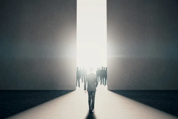 Homme d'affaires marchant vers une ouverture abstraite avec une lumière vive et des silhouettes de personnes à l'intérieur en béton. Concept de réussite. Rendu 3D — Photo