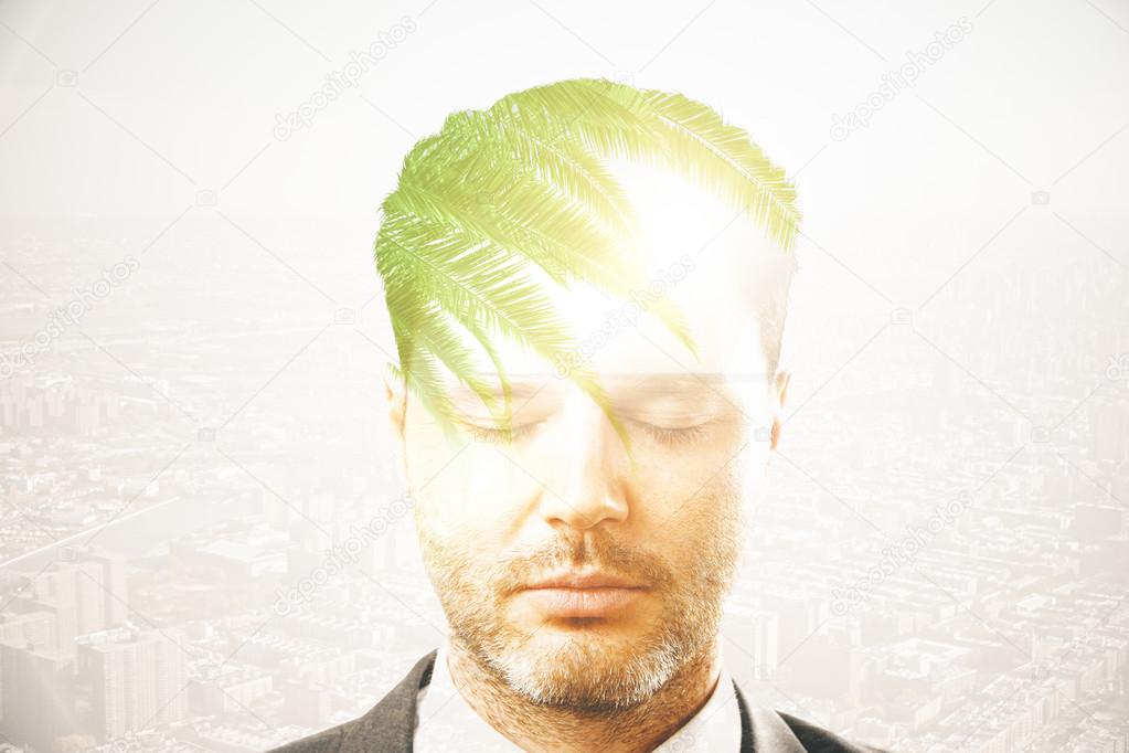 Portrait of handsome young businessman thinking about holidays on city background. Overworked concept. Double exposure