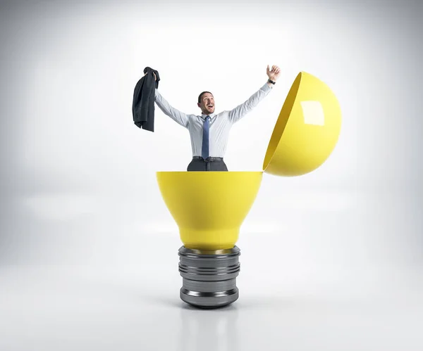 幸せなビジネスマンの大きな黄色の電球に座っている 成功とスタートアップのコンセプト — ストック写真