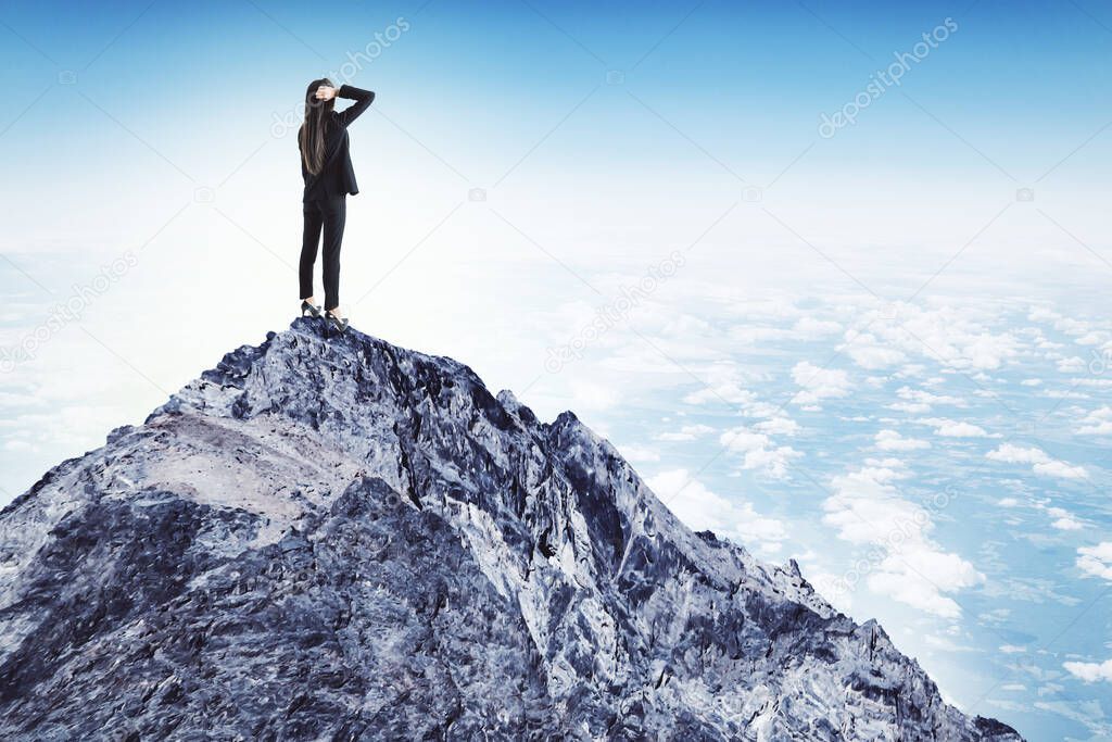 Businesswoman in suit standing on mountain. Leadership and success concept