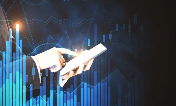 Business trading concept with man using digital tablet at financial graphs background.Double exposure.