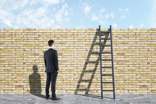 商人在砖墙上看木制楼梯 领导能力和职业发展概念 — 图库照片