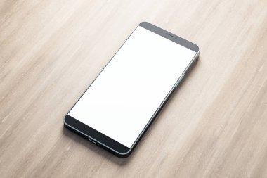 Ahşap masadaki boş beyaz ekranlı modern cep telefonu. Teknoloji ve iletişim konsepti. Model yap. 3B Hazırlama
