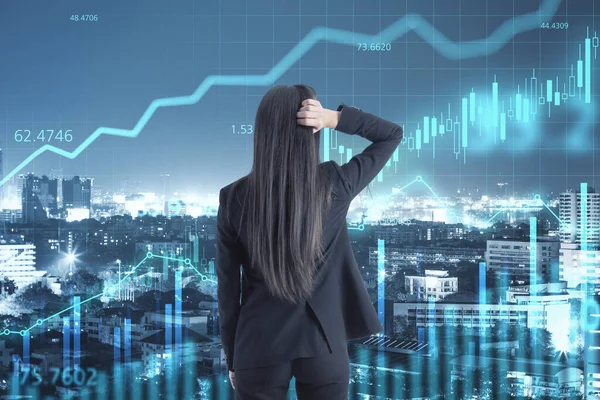 Businesswoman holding her head to find a solution at night city background and digital screen with glowing candles and stock market graphs. Double exposure.