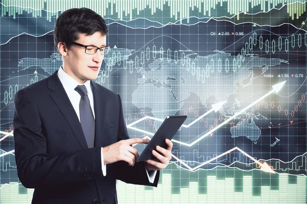 Trade market analysis concept with businessman looking at digital tablet at digital scoreboard with financial chart graphs and arrows background. Double exposure