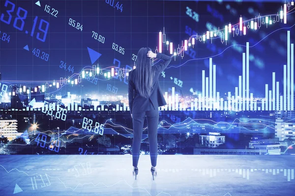 Online trade market success with businesswoman looking at big digital screen with growing up financial chart quotes and diagram at night city background. Double exposure