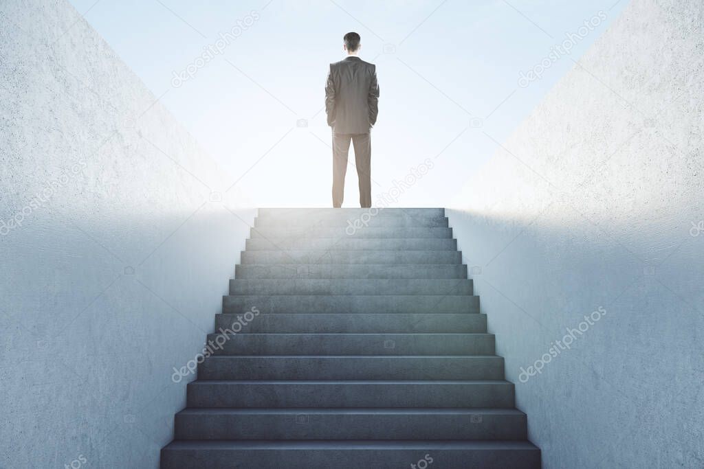 Business success concept with businessman on top of stairs looking at blue sky