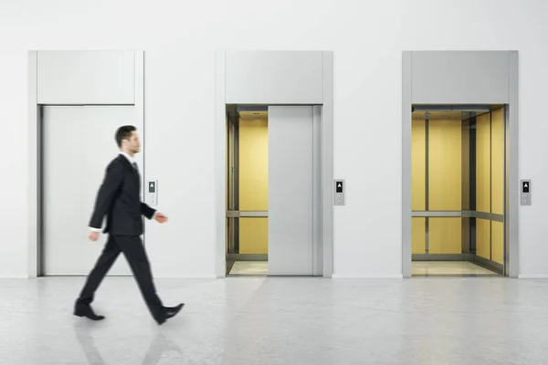 Affärsman Promenader Vit Betong Interiör Med Tre Hiss Dörrar Begreppet — Stockfoto