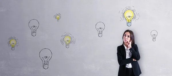 Nachdenkliche Junge Europäische Geschäftsfrau Mit Abstrakter Lampenskizze Auf Betonwandhintergrund Idee — Stockfoto