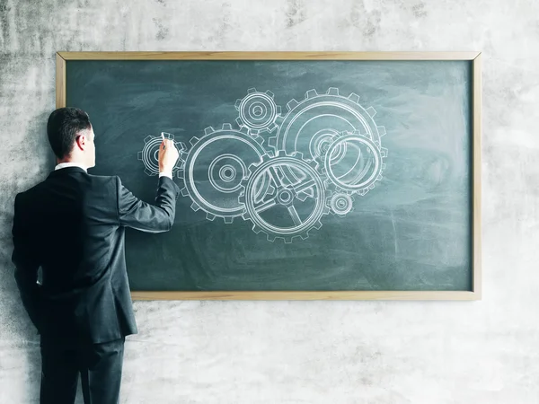 Businessman drawing gears — Stock Photo, Image