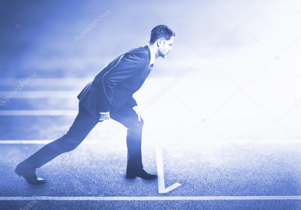Businessman standing on running track