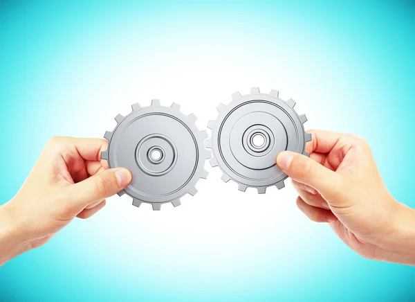 Hands connecting gears — Stock Photo, Image