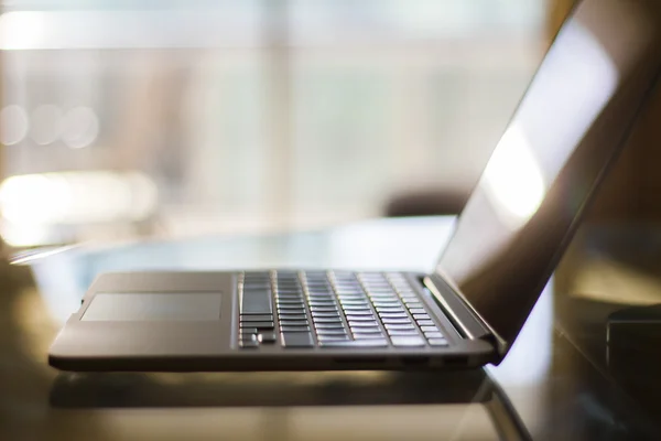 Modern laptop on glass table — Stock Photo, Image