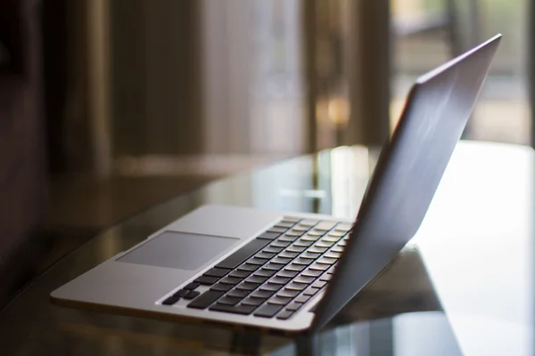 Modern laptop on glass table — Stock Photo, Image