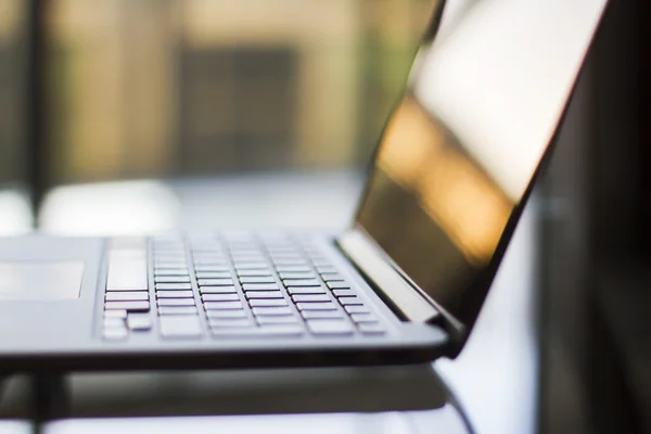 Laptop na mesa de vidro — Fotografia de Stock