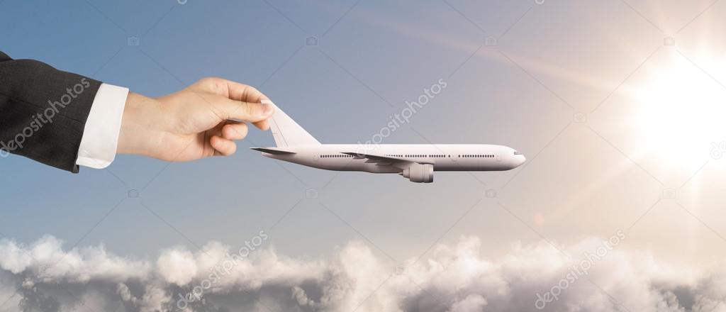 businessman hand holding airplane