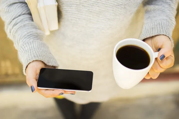 Cep telefonu, kupa ve kitaplar ile kız — Stok fotoğraf