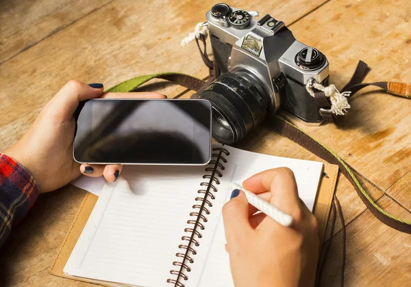Дівчина з телефоном, щоденником і камерою — стокове фото