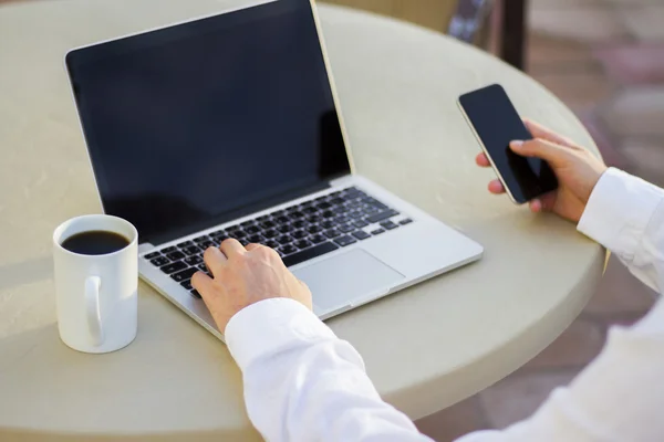 Empresário trabalhando com celular e laptop — Fotografia de Stock